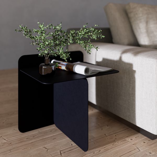 Cairo Side Table — Black side table with a plant and magazine next to a beige sofa.