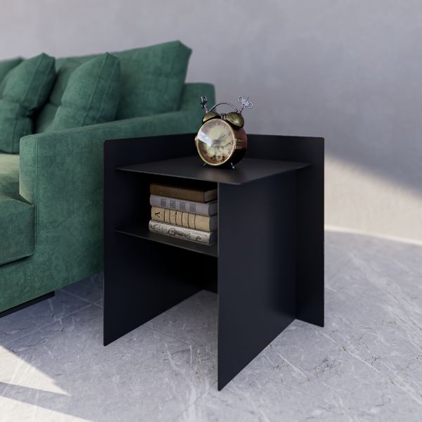 Connor Side Table (Right Hand) — Black side table with books and an alarm clock next to a green sofa in a room.