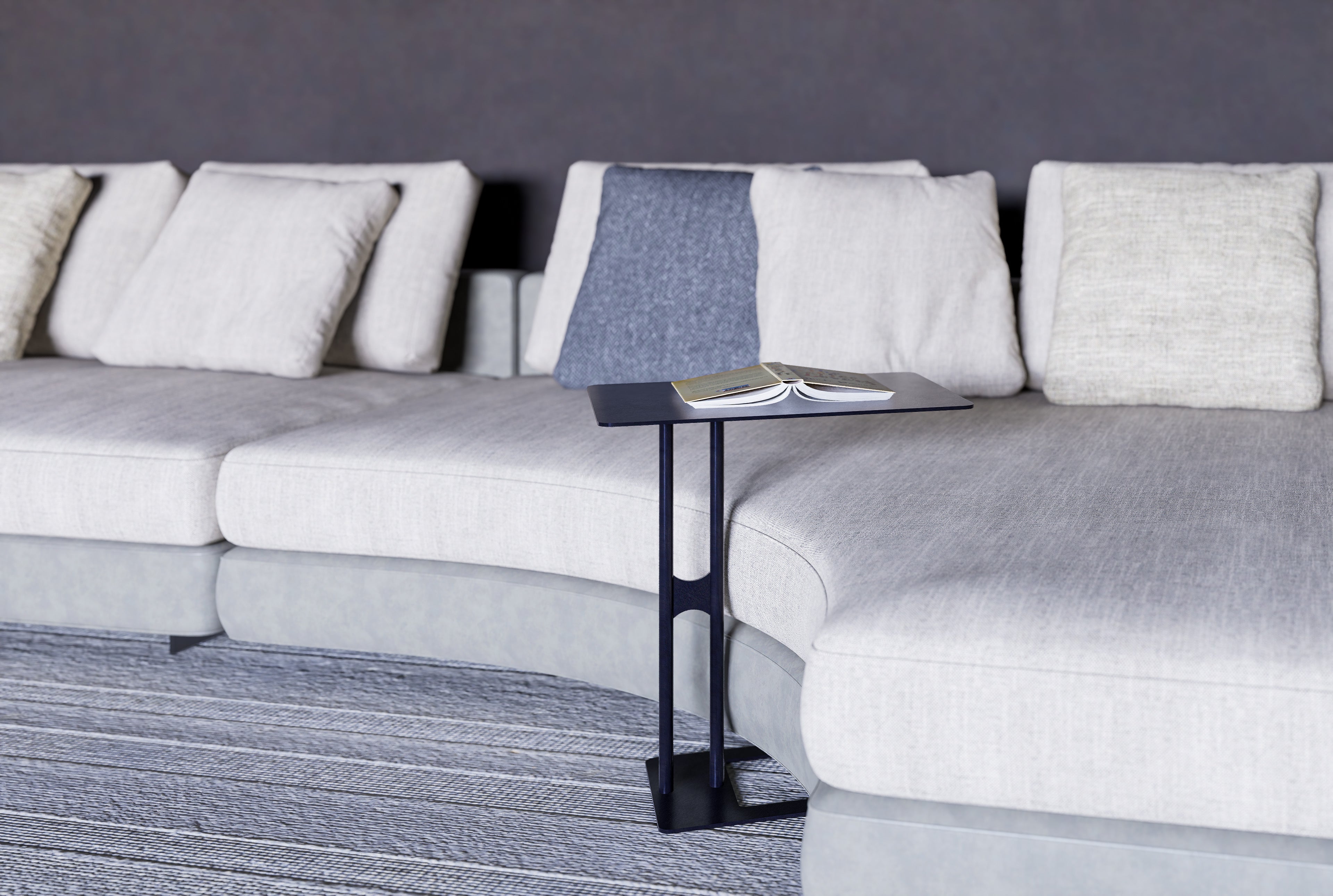 Lizzy Side Table — Gray sectional sofa with a small table and magazine on a gray carpet.