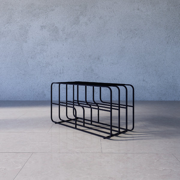 Medellín shoe rack stand – black metal bike rack on a gray floor with a gray concrete wall background