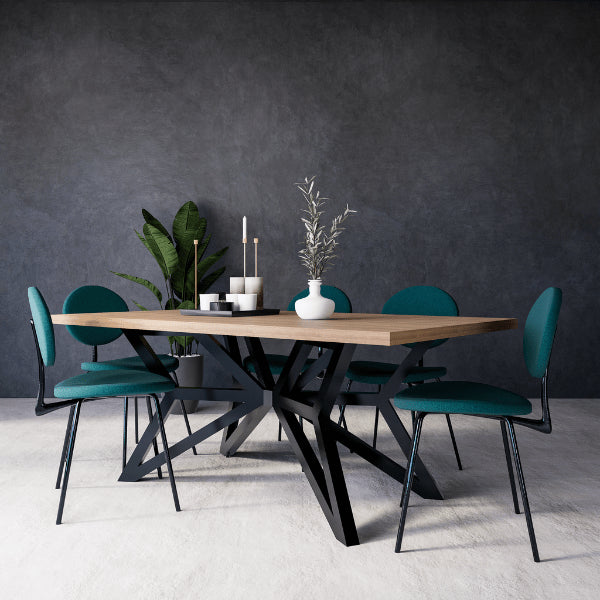 Seraphina dining table with four teal chairs against a dark gray wall
