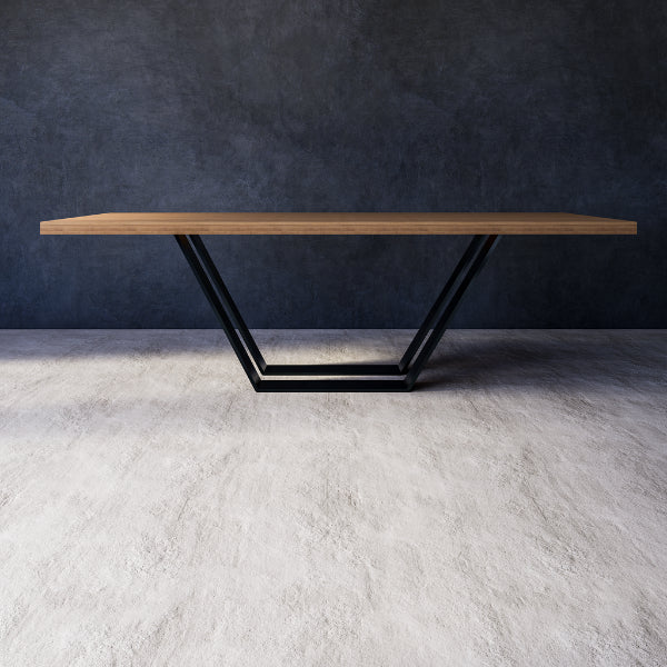Stella dining table with wooden top and black metal legs against a dark wall on a gray floor